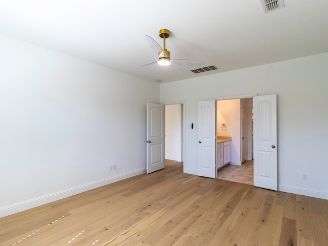 unfurnished bedroom featuring light hardwood / wood-style flooring, ensuite bath, and ceiling fan