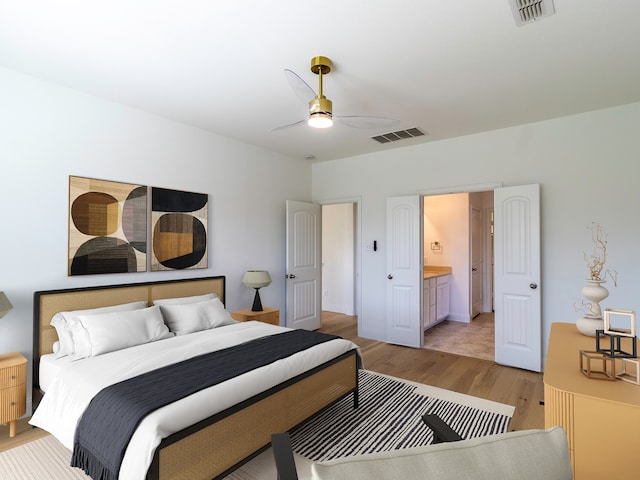 bedroom featuring ceiling fan, ensuite bathroom, and light wood-type flooring