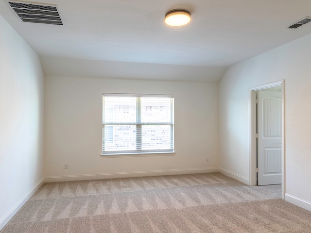 empty room with light carpet and lofted ceiling