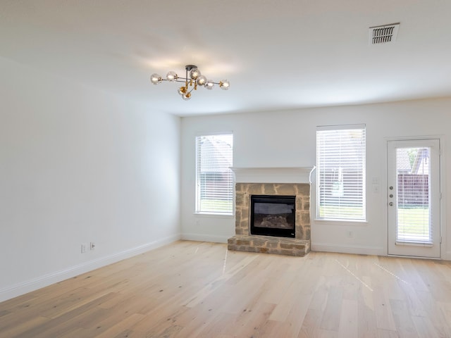 unfurnished living room with light hardwood / wood-style flooring, a fireplace, and plenty of natural light