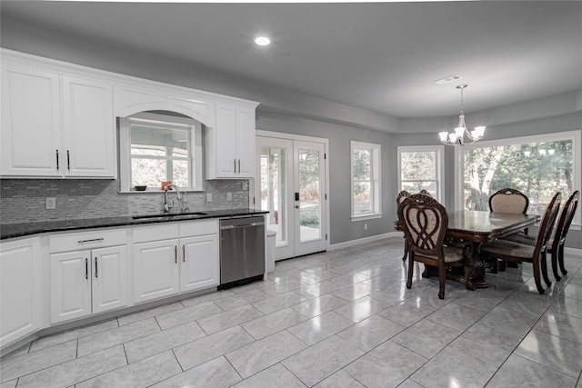 kitchen featuring stainless steel dishwasher, sink, white cabinetry, and plenty of natural light