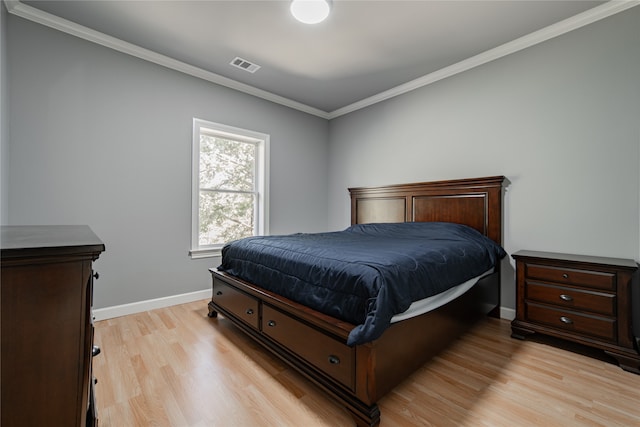 bedroom featuring ornamental molding and light wood-type flooring