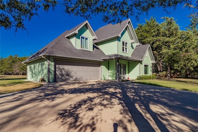 view of front of home with a front yard and a garage