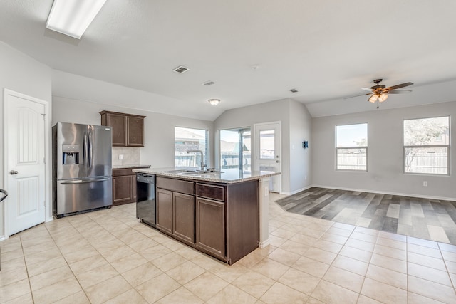 kitchen with dishwasher, a wealth of natural light, an island with sink, and stainless steel refrigerator with ice dispenser