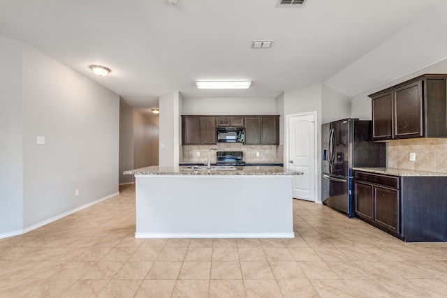 kitchen featuring black appliances, dark brown cabinets, light stone counters, and backsplash