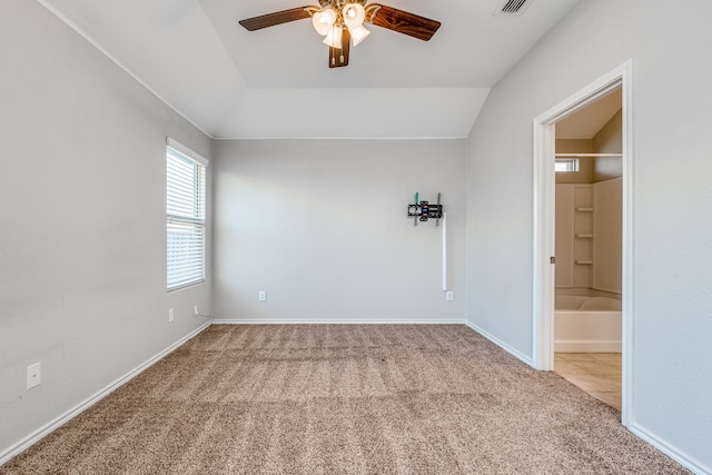 carpeted spare room featuring ceiling fan and vaulted ceiling