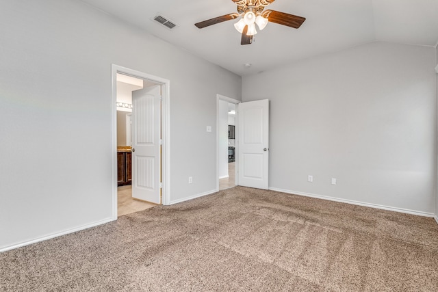 unfurnished bedroom featuring ceiling fan, lofted ceiling, light colored carpet, and ensuite bathroom