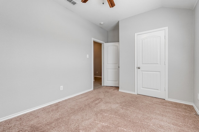 unfurnished bedroom with light carpet, vaulted ceiling, and ceiling fan