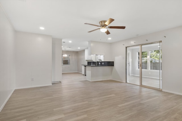 unfurnished living room featuring ceiling fan and light wood-type flooring