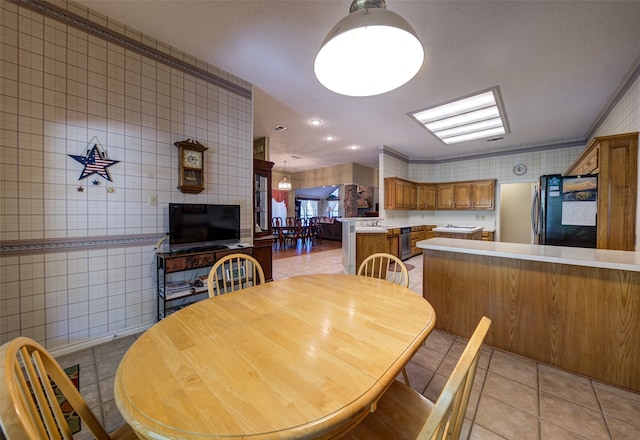 tiled dining area with tile walls and ornamental molding