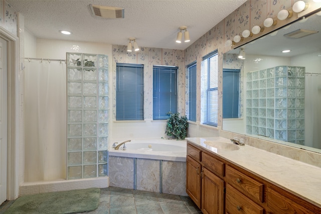 bathroom with vanity, shower with separate bathtub, a textured ceiling, and tile patterned flooring