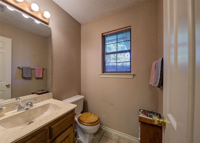 bathroom with tile patterned floors, vanity, a textured ceiling, and toilet