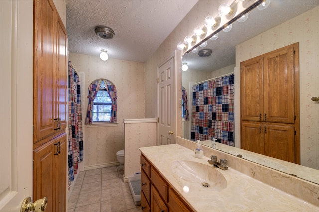 bathroom featuring tile patterned flooring, vanity, a textured ceiling, and toilet