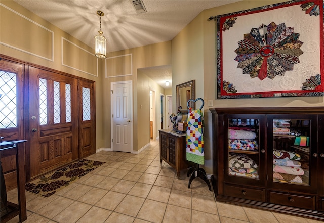 tiled entrance foyer featuring a textured ceiling