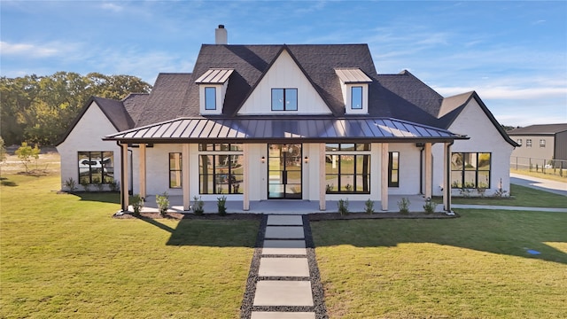 back of property with covered porch and a lawn