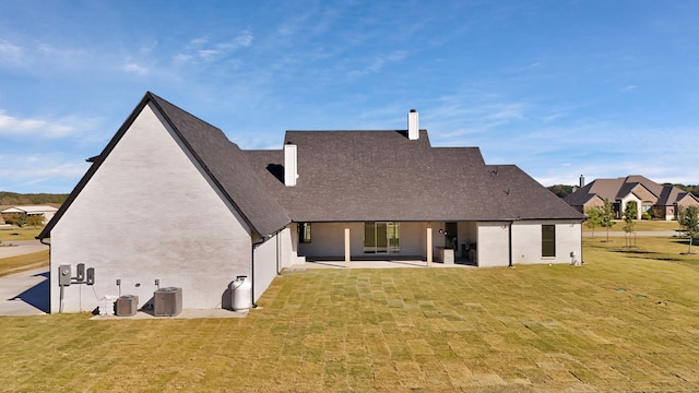 rear view of property with a yard, a patio, and central AC unit