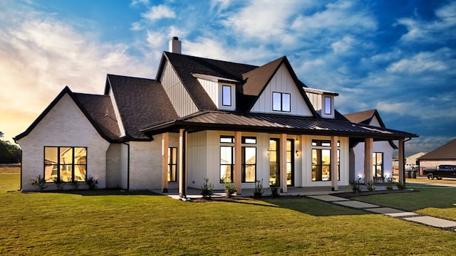 back of property with french doors and a lawn