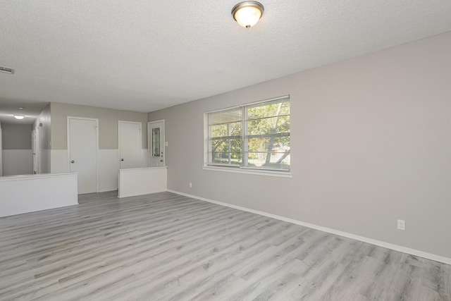 509 Ridgeview Dr, Rockwall, TX 75087 - unfurnished living room with a textured ceiling, light wood finished floors, and baseboards