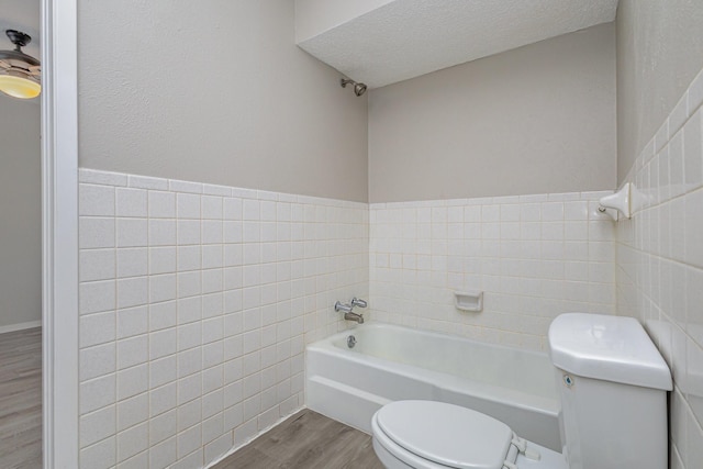 509 Ridgeview Dr, Rockwall, TX 75087 - bathroom with toilet, wood finished floors, tile walls, a bath, and a textured ceiling