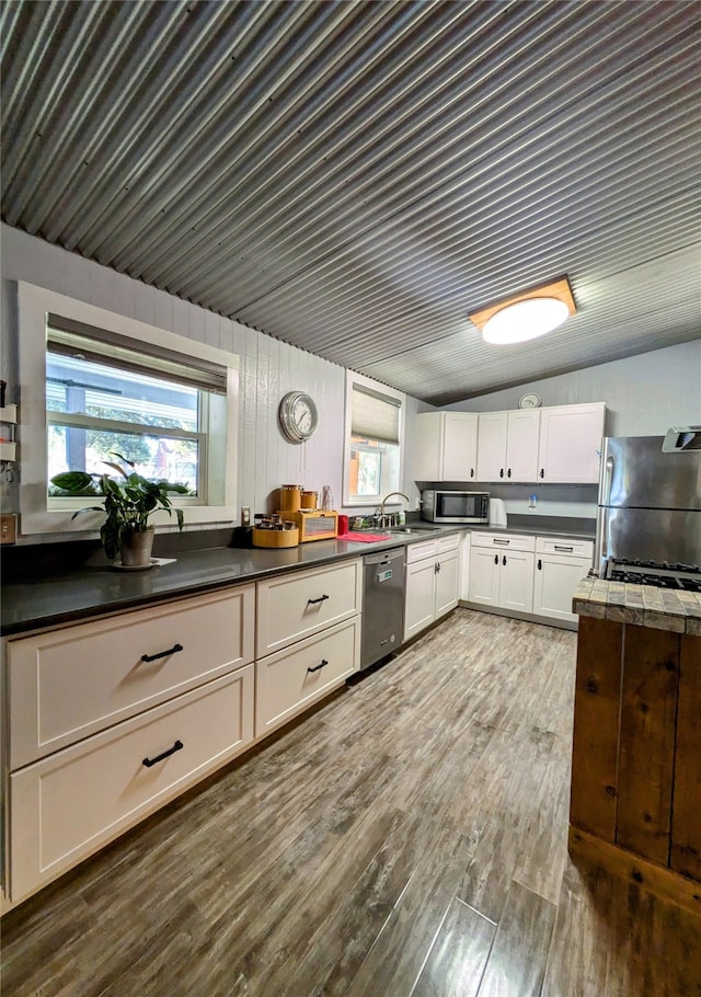 kitchen with dark hardwood / wood-style floors, white cabinetry, sink, and appliances with stainless steel finishes