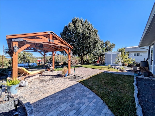 view of yard with a gazebo, a playground, a storage unit, and a patio area