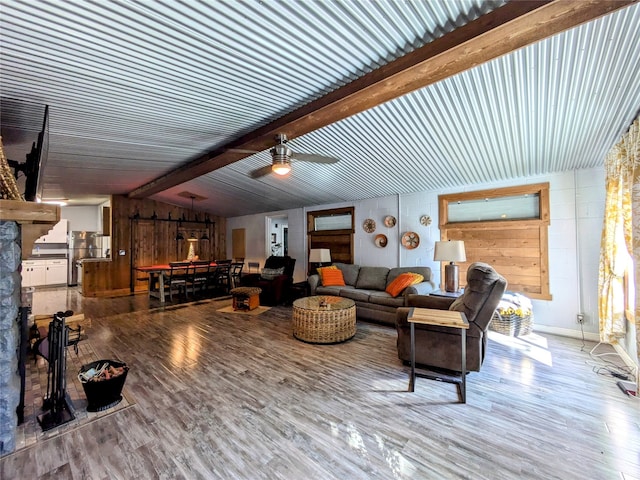 living room featuring vaulted ceiling with beams, ceiling fan, light hardwood / wood-style flooring, and wood walls