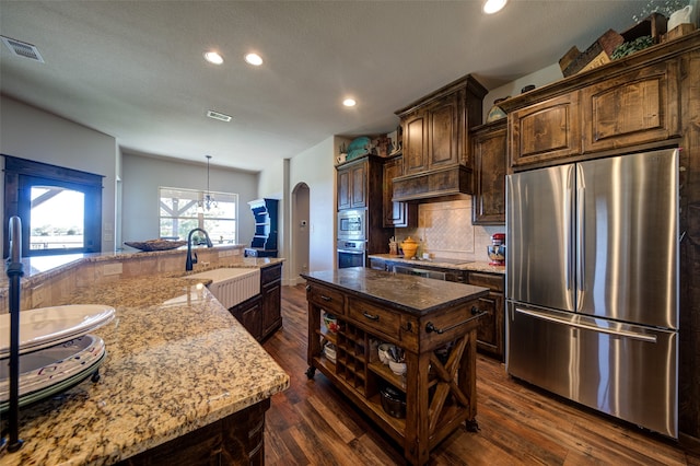 kitchen featuring a large island, dark hardwood / wood-style floors, dark brown cabinetry, and appliances with stainless steel finishes