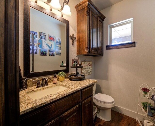 bathroom with hardwood / wood-style flooring, vanity, and toilet