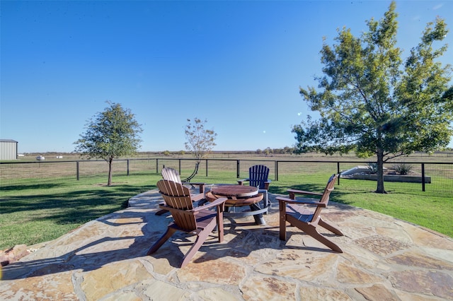 view of patio with a rural view and a fire pit