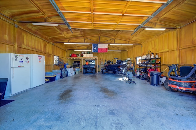 garage with wooden walls and white refrigerator