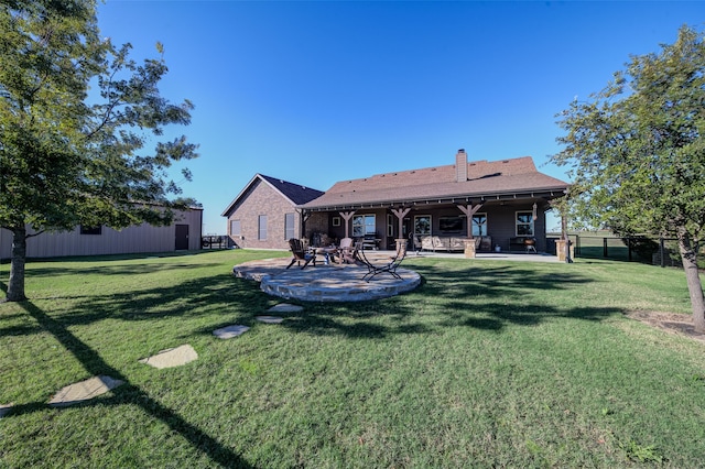 rear view of house featuring a lawn and a patio area