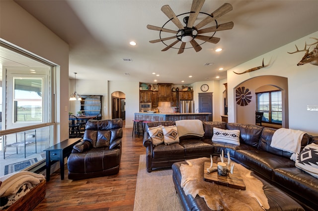 living room featuring wood-type flooring and ceiling fan with notable chandelier