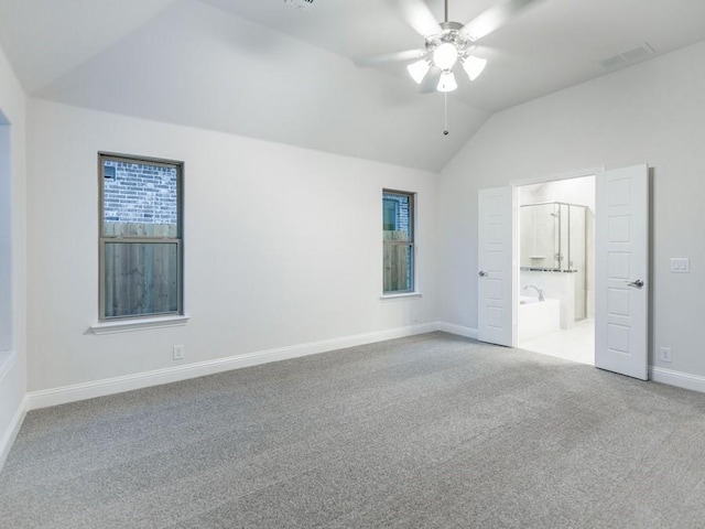 unfurnished bedroom featuring lofted ceiling, ensuite bathroom, ceiling fan, and carpet