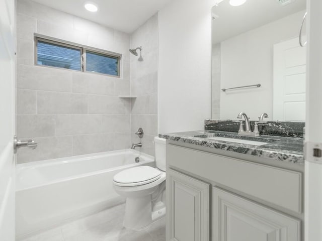 full bathroom with tiled shower / bath, vanity, and toilet