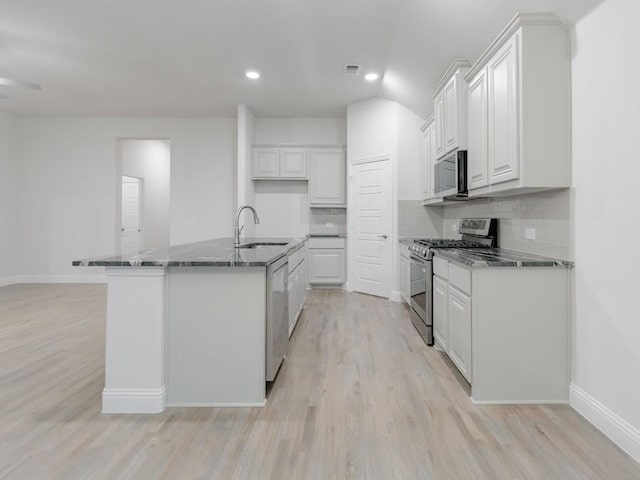 kitchen featuring white cabinetry, sink, light hardwood / wood-style floors, stainless steel appliances, and a center island with sink