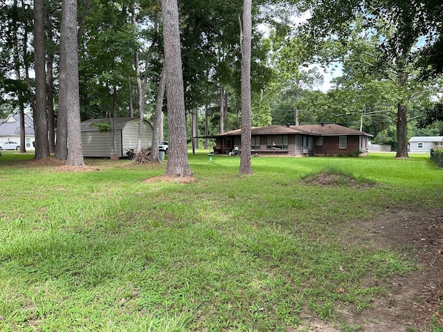 6371 Buncombe Rd, Shreveport, LA 71129 - view of yard featuring a storage unit, a detached carport, and an outbuilding