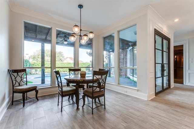 dining area featuring a wealth of natural light, ornamental molding, and light hardwood / wood-style floors