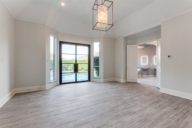 unfurnished room with light hardwood / wood-style floors, crown molding, and vaulted ceiling