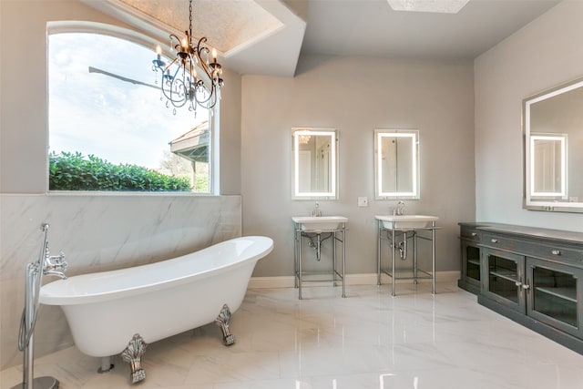 bathroom with a bath, a chandelier, and vanity