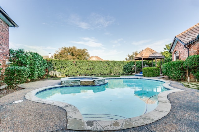 view of pool with an in ground hot tub and a gazebo