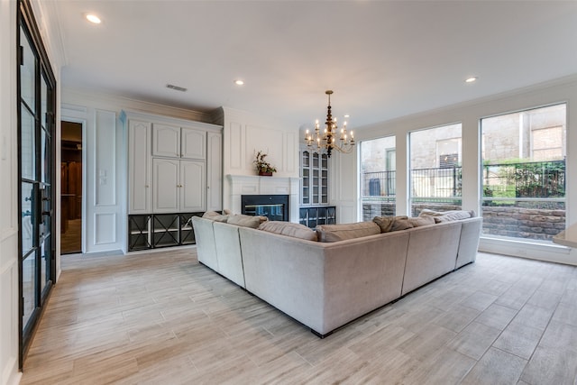 unfurnished living room featuring crown molding, an inviting chandelier, and light hardwood / wood-style floors