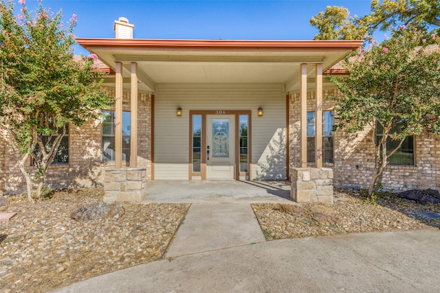 view of exterior entry with covered porch