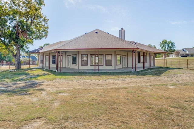 rear view of property with a yard and a patio area