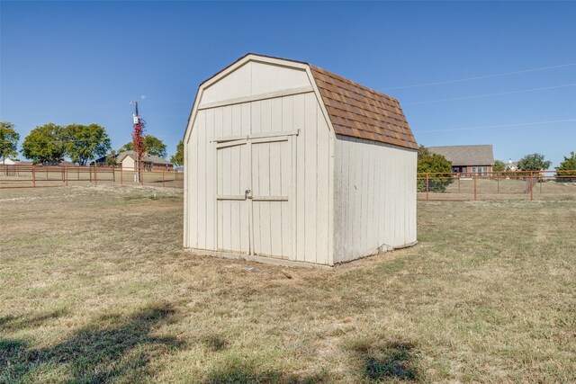 view of outdoor structure with a lawn and a rural view