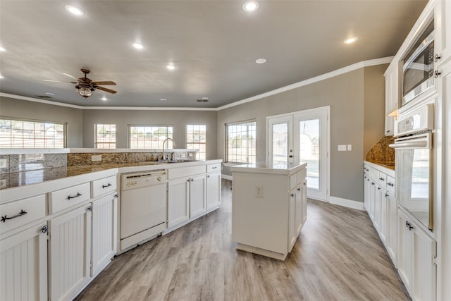 kitchen featuring white appliances, light hardwood / wood-style floors, sink, and plenty of natural light