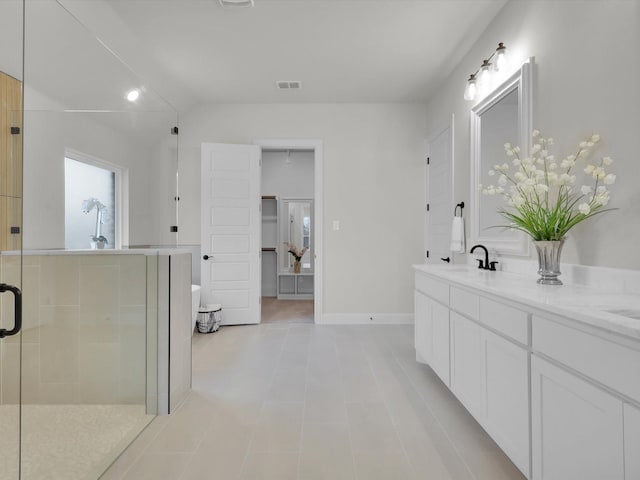 bathroom featuring tile patterned flooring, vanity, and a shower with door