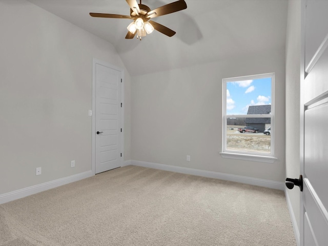 unfurnished room with ceiling fan, light colored carpet, and vaulted ceiling