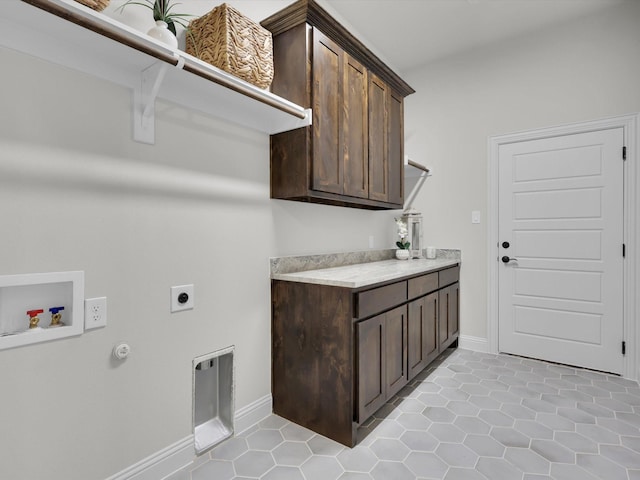 clothes washing area featuring light tile patterned flooring, gas dryer hookup, cabinets, washer hookup, and electric dryer hookup