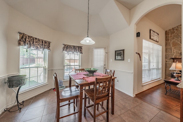 dining space featuring wood-type flooring and high vaulted ceiling