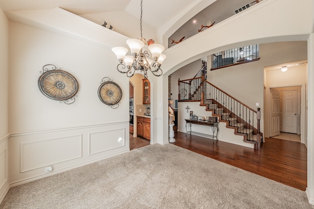 spare room with a notable chandelier, dark hardwood / wood-style floors, and high vaulted ceiling